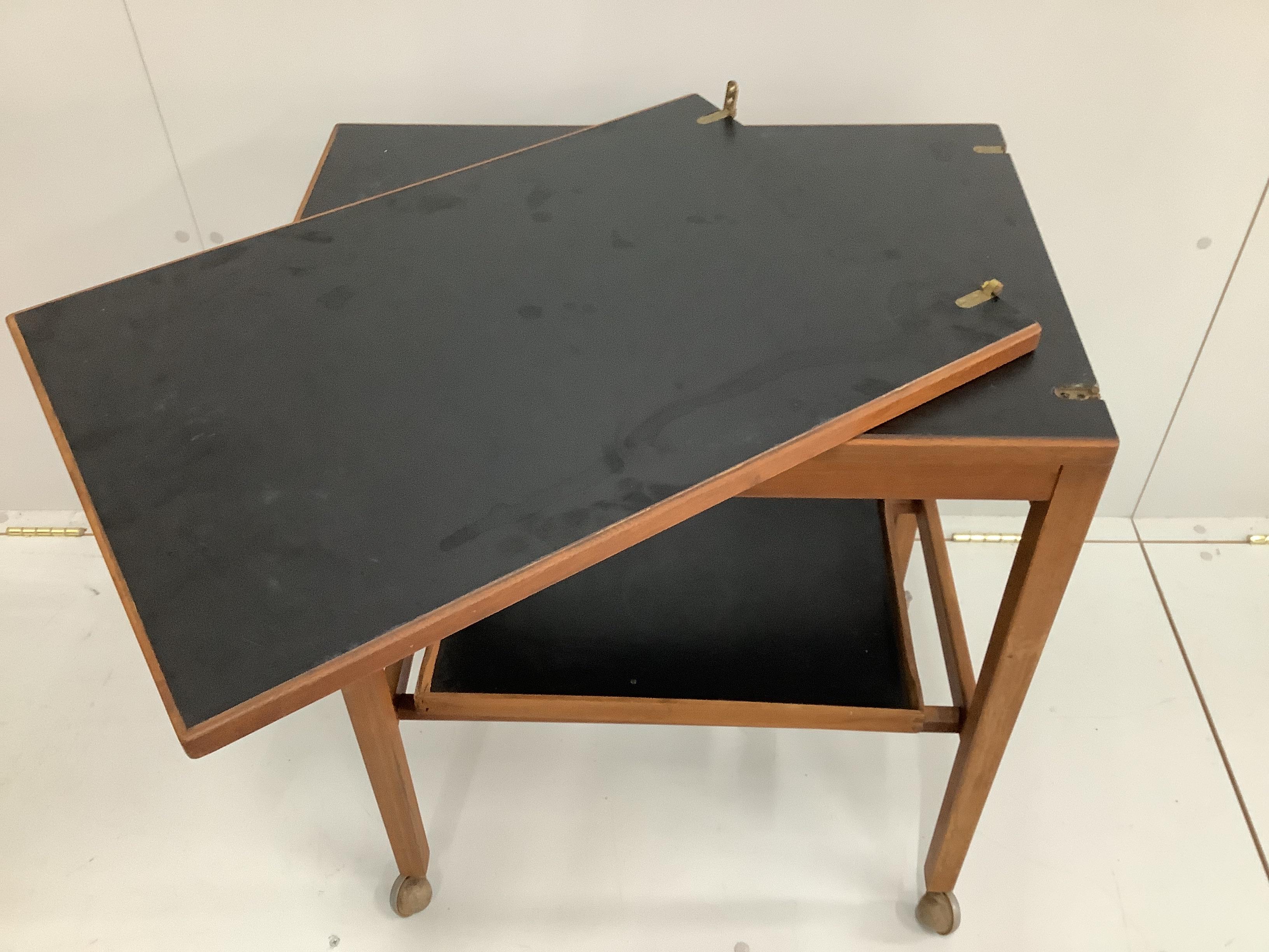 A mid century teak two tier occasional table, width 50cm, depth 38cm, height 68cm together with a nest of two rectangular teak tea tables and a hinge top tea trolley